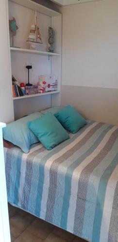 - un lit avec des oreillers bleus dans une chambre dans l'établissement Le PANORAMIC, au Cap d'Agde