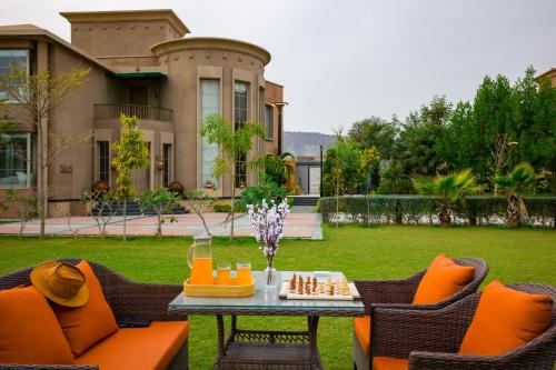 a patio with a chess game on a table in front of a house at ELIVAAS Noahs Ark 3 BHK Villa with Pvt Pool, Garden & Gazebo in Jaipur