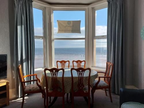 a dining room with a table and chairs in front of a window at Brigg View Holiday Apartment in Filey