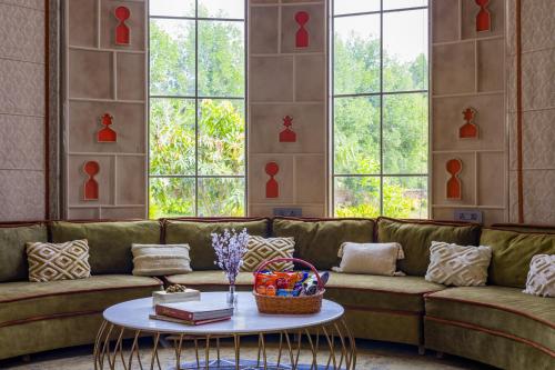 a living room with a green couch and a table at ELIVAAS Noahs Ark 3 BHK Villa with Pvt Pool, Garden & Gazebo in Jaipur