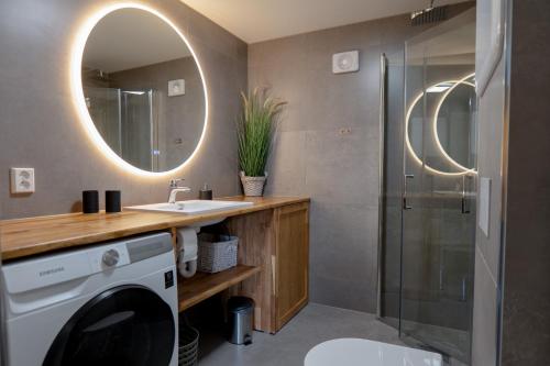 a bathroom with a washing machine and a mirror at KS Apartment Modern & cozy flat 20 min from Bergen centre in Espeland