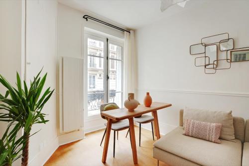 - un salon avec une table, une chaise et une fenêtre dans l'établissement 2 pièces au coeur de Montmartre - proche Sacré Coeur, à Paris