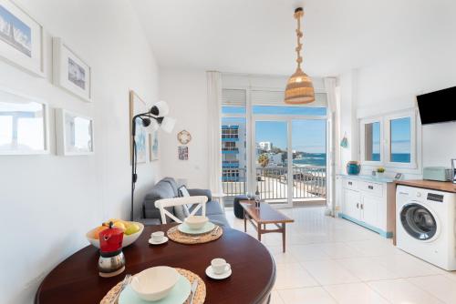a living room with a table and a kitchen with a balcony at Atlantic Sunsets By Agüita Salada in Bajamar
