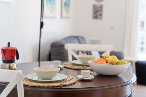 a coffee table with bowls of fruit on it at Atlantic Sunsets By Agüita Salada in Bajamar