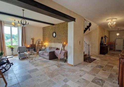 a large living room with a bed and a table at Aux roses de Cèdres in Salvagnac