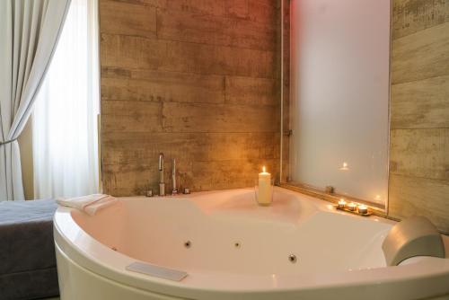 a bath tub with a candle in a bathroom at Corso Boutique Luxury Rooms in Rome