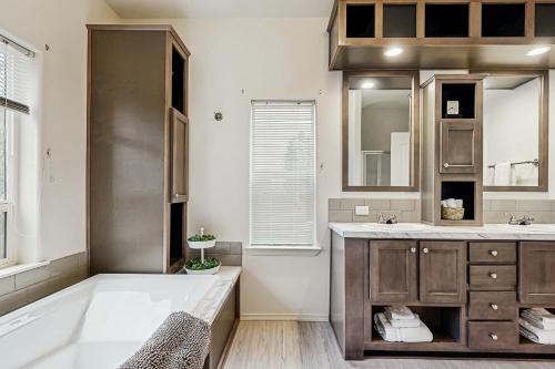 a bathroom with a tub and a sink and a mirror at Water's Edge Escape in Chelan