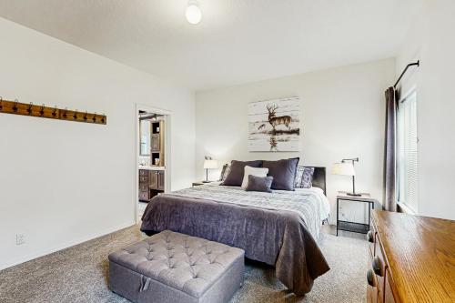 a white bedroom with a bed and a chair at Water's Edge Escape in Chelan