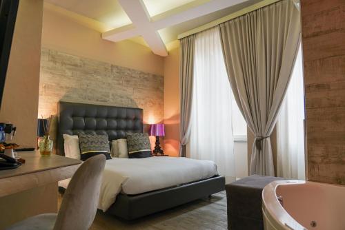 a bedroom with a large bed and a bath tub at Corso Boutique Luxury Rooms in Rome