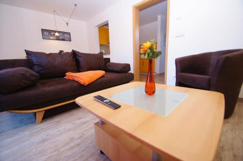 un salon avec un canapé et une table dans l'établissement Bungalow Timm, à Kellenhusen