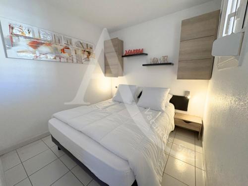 une chambre blanche avec un lit et un bureau dans l'établissement 4 PERS, 1 CHAMBRE, PLAGES ET COMMERCES A PIED, à Sète