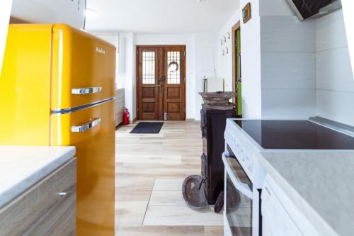 a kitchen with a yellow refrigerator and a stove at Apartment Grič with Sauna in Stari Trg pri Ložu