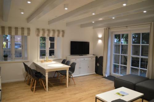 ein Wohnzimmer mit Tisch und Fernseher in der Unterkunft Haus Boldix Whg 1 Aruba in Boldixum