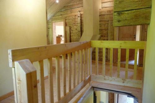 a wooden staircase in a house with a wooden wall at Charmantes Strickhaus im Val Lumnezia in Vigens