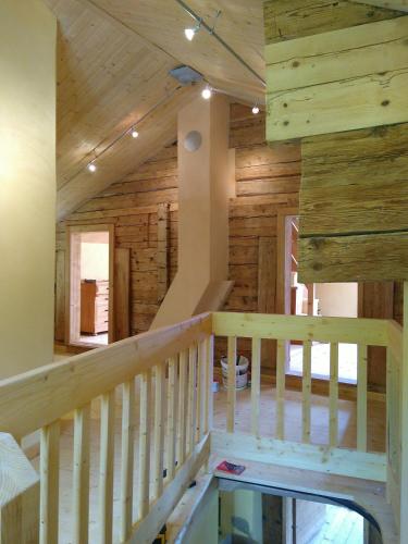 a staircase in a log cabin with wooden walls at Charmantes Strickhaus im Val Lumnezia in Vigens