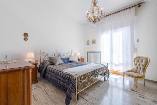 Un dormitorio con una cama, una silla y una lámpara de araña. en Appartamento Diaz In Colle Val D'elsa, en Colle Val D'Elsa