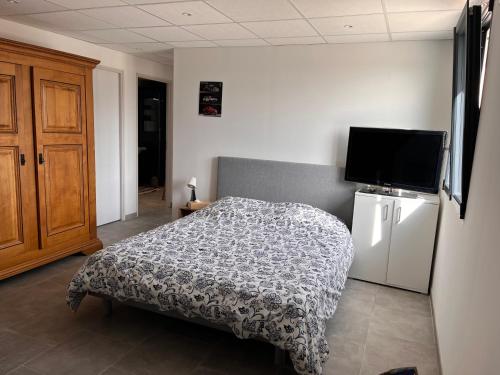 une chambre avec un lit et une télévision à écran plat dans l'établissement Appartement Les Faysses, à Rochemaure