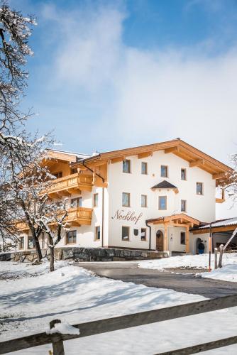 a large building in the snow with a fence at Nockhof in Terfens
