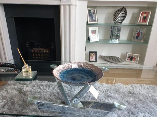 a glass table in a living room with a chair at Family Home Stay in Thornton Heath