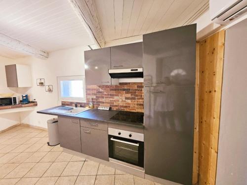 une cuisine avec un réfrigérateur en acier inoxydable et un évier dans l'établissement Charmant T2 des bourgades, à Caumont-sur-Durance