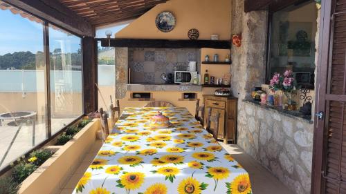 - une cuisine avec une table et des tournesols dans l'établissement La Maison des Mots et des Notes, à Roquebrune-Cap-Martin
