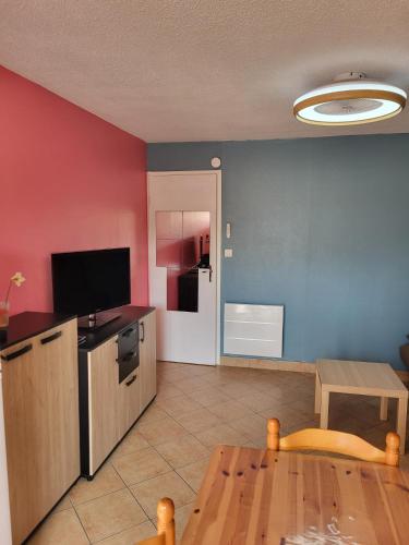 un salon avec une table et une cuisine dans l'établissement Le Cap D'agde appt T2, R d C , entièrement rénové, au Cap d'Agde