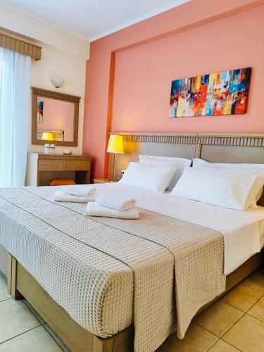Perdika Resort في بيرديكا: غرفة نوم بها سرير كبير عليه منشفتين