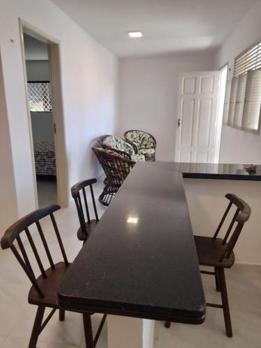 a black table and chairs in a living room at Casa Aconchegante Bem Localizada in Natal