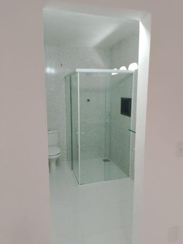 a bathroom with a glass shower and a toilet at Casa Aconchegante Bem Localizada in Natal