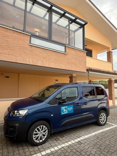 a blue car parked in front of a building at SIGIS HOTEL - Fiumicino in Fiumicino