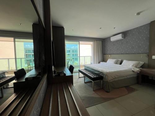 a bedroom with a bed and a large window at Flat na Beira do Lago in Brasilia