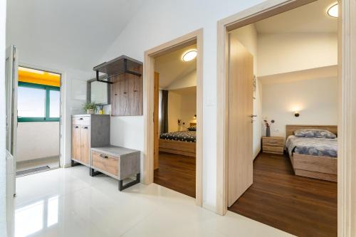 a room with two beds and a door to a bedroom at Sea View Apartment Betina, Murter in Betina