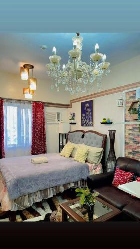 a bedroom with a large bed and a chandelier at Sunvida Tower 2819-2818 in Cebu City