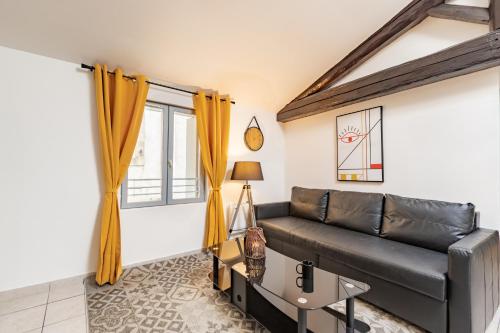Una sala de estar con un sofá de cuero negro y una mesa. en Evasion chic au cœur de Béziers, en Béziers
