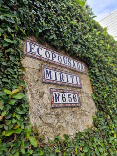 a sign on the side of a wall with plants at Ecopousada Miriti in Belém