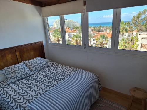 a bedroom with a bed with a view of the ocean at Chill out Apartment Tenerife in Arona