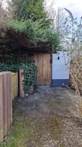 a garage with a wooden door and a fence at Glücksburg Strandnah an der Förde in Glücksburg