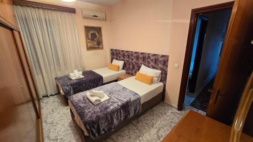 a hotel room with two beds and a window at Fani apartment in Ouranoupoli