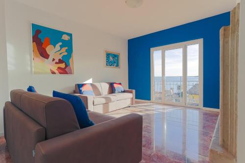 a living room with two couches and blue walls at Magnifica Terrazza - Lake View in Gardone Riviera