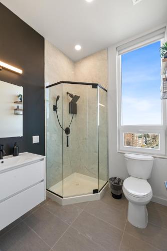 a bathroom with a shower and a toilet and a window at 2BR, King Bd, Free Prkn, Gym, NYC View, 8min Train in East Orange