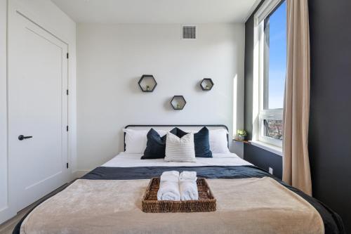 a bedroom with a bed with two towels on it at 2BR, King Bd, Free Prkn, Gym, NYC View, 8min Train in East Orange