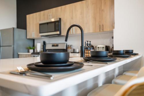 a kitchen counter with black bowls and utensils on it at 2BR, King Bd, Free Prkn, Gym, NYC View, 8min Train in East Orange