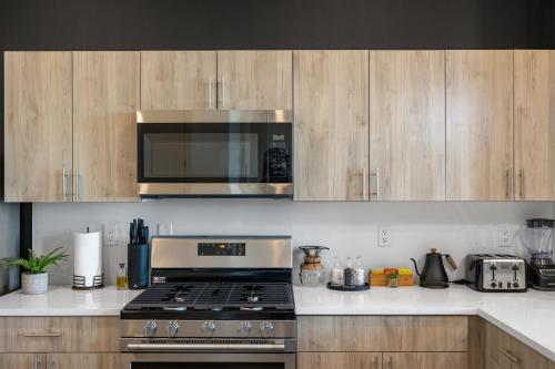 a kitchen with a stove and a microwave at 2BR, King Bd, Free Prkn, Gym, NYC View, 8min Train in East Orange
