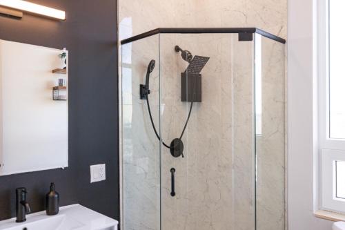 a shower with a glass door in a bathroom at 2BR, King Bd, Free Prkn, Gym, NYC View, 8min Train in East Orange