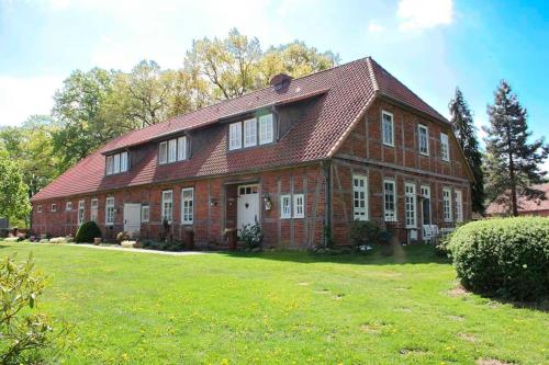 a large brick house with a red roof at Hof Esterau - Appartment gelb in Heuerstorf