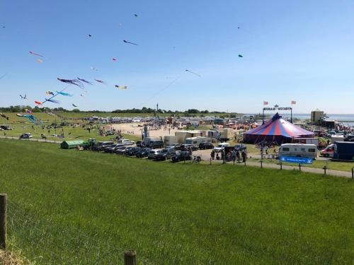 a group of people flying kites in a parking lot at Deichkieker in Butjadingen