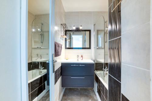 une salle de bain avec un lavabo et un miroir dans l'établissement Super Appart sur l ile des pêcheurs, au Cap d'Agde