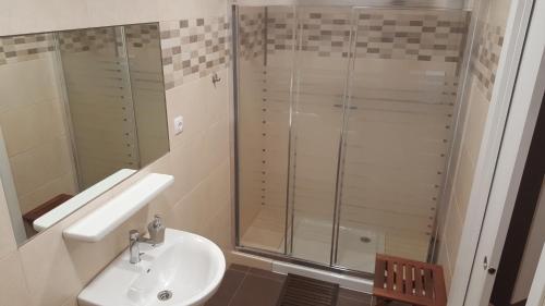 uma casa de banho com uma cabina de duche em vidro e um lavatório. em Pensión Avenida em Vilafranca del Penedès