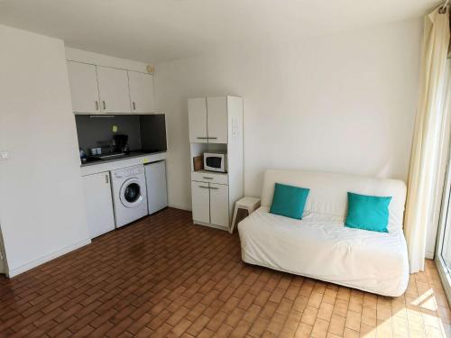une chambre avec un lit avec des oreillers bleus dessus dans l'établissement Studio cabine 20m de la plage avec parking - Cap d'Agde - FR-1-607-71, au Cap d'Agde
