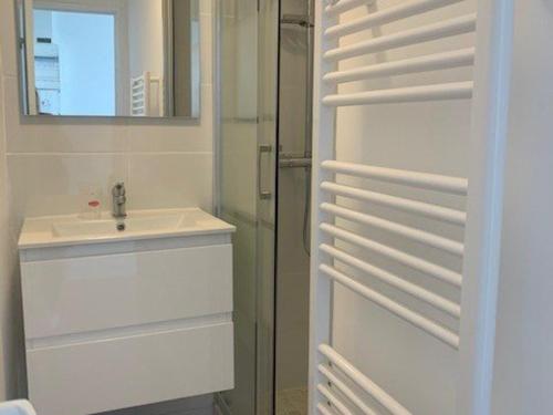 une salle de bain blanche avec un lavabo et un miroir dans l'établissement Studio cabine 20m de la plage avec parking - Cap d'Agde - FR-1-607-71, au Cap d'Agde